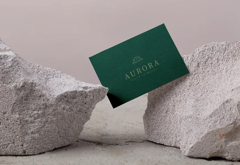 Cartão de visita verde com logo dourado de marca fictícia